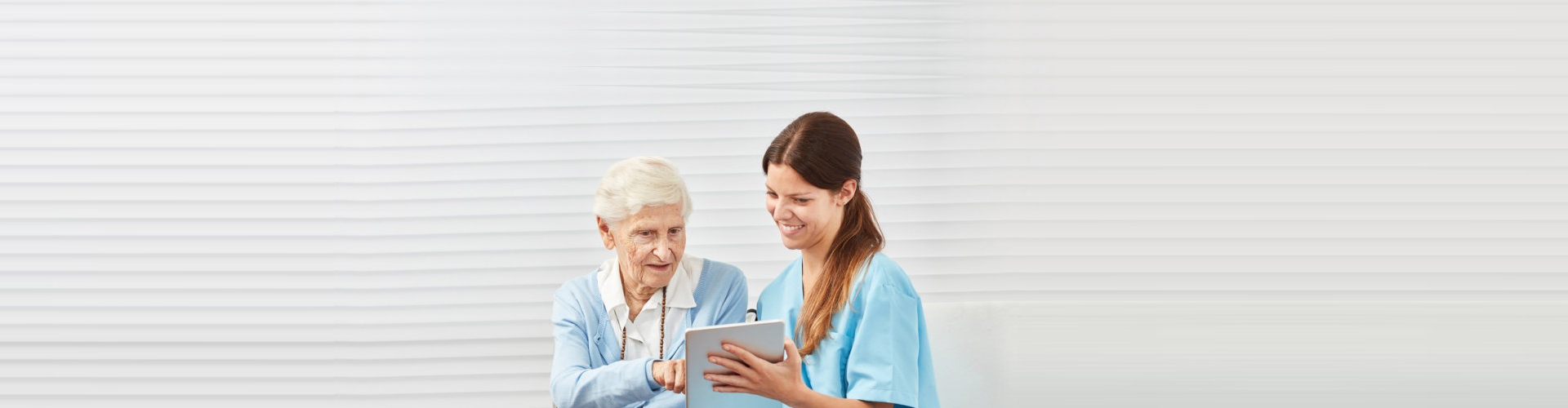 caregiver helping patient with her ipad